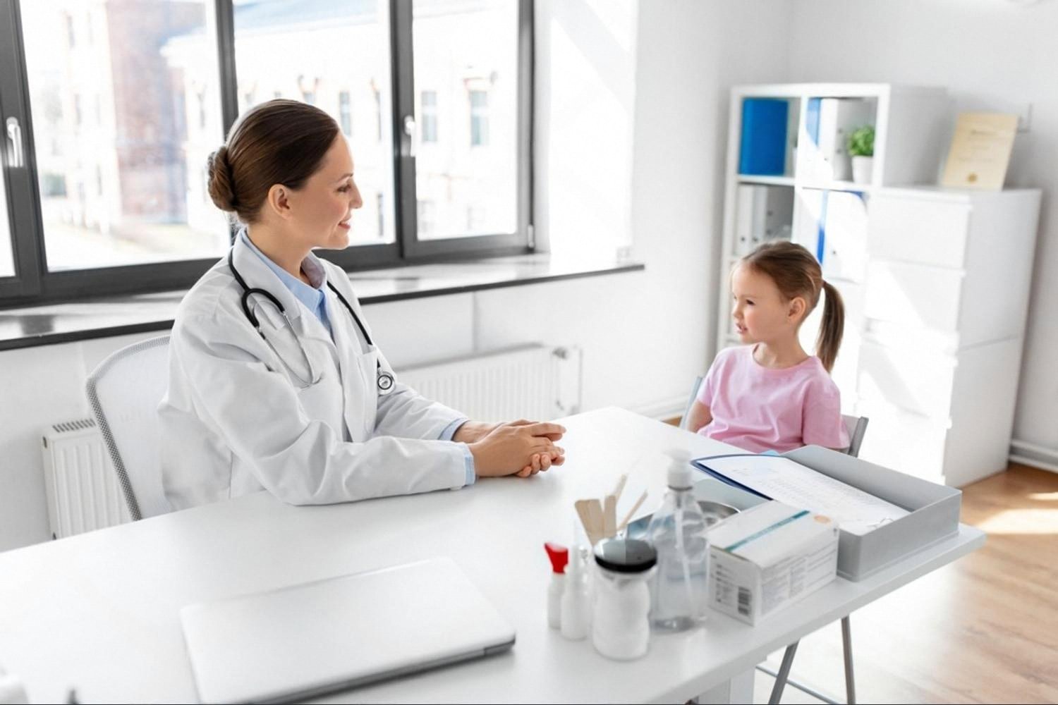 Female doctor consulting a young patient during a scheduled appointment in a bright clinic office